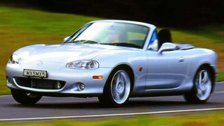 Mazda MX-5 grise roulant sur route