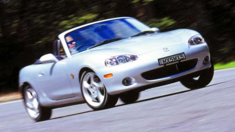 Mazda MX-5 grise roulant sur route