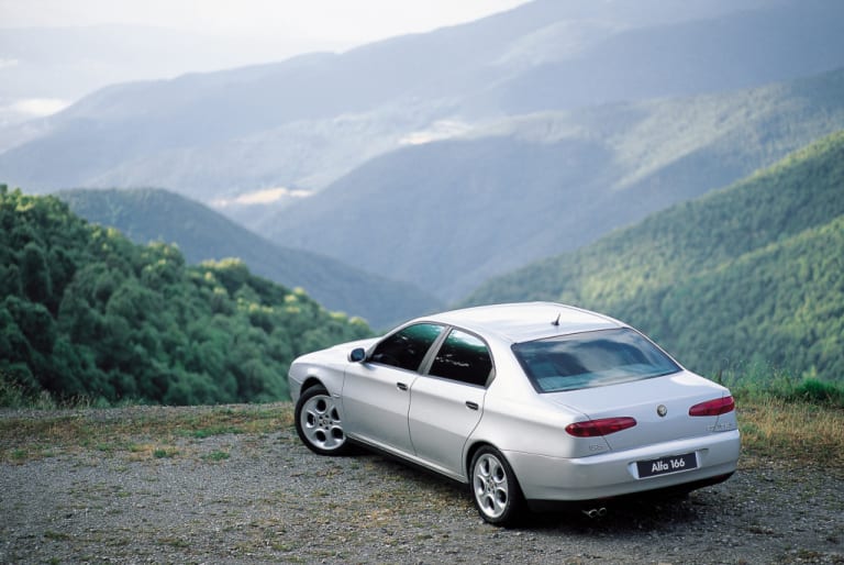 Alfa Romeo 166 sur un point de vue avec les montagnes en arrière plan