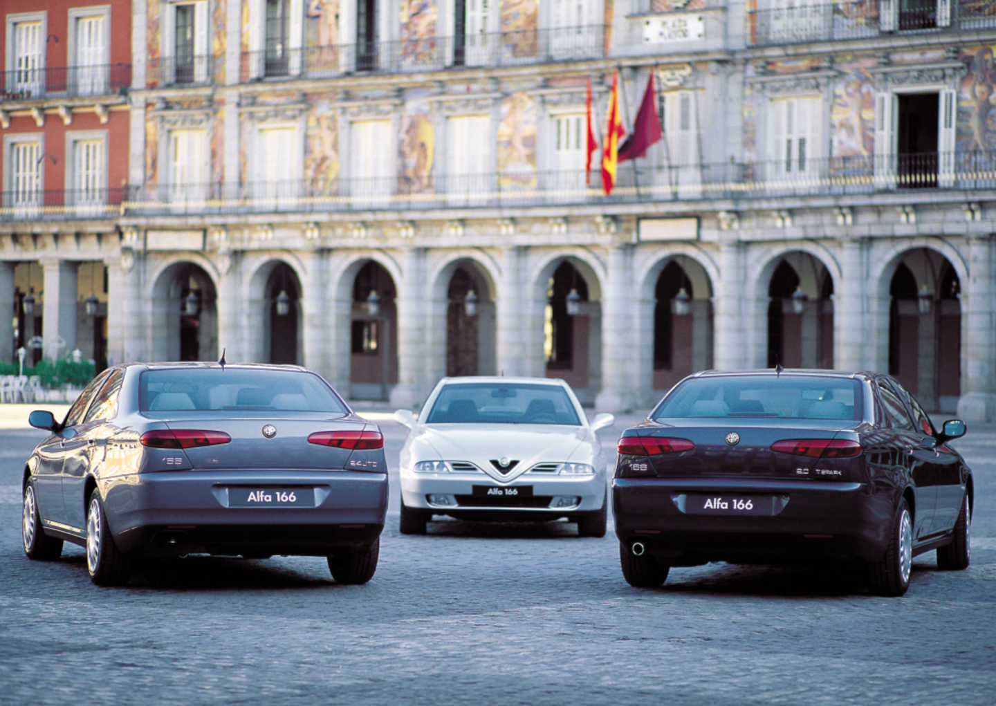 3 Alfa Romeo 166 dans une cours, une blanche, une grise et une noire