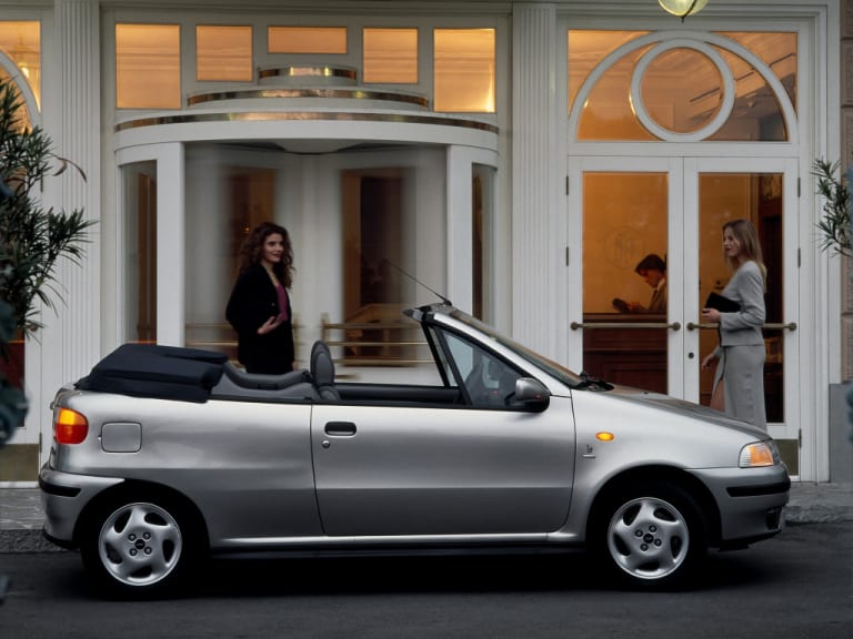 Punto Cabriolet grise de profil devant un hôtel de luxe