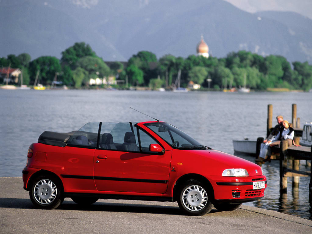 Punto Cabriolet rouge de profil au bord de l'eau