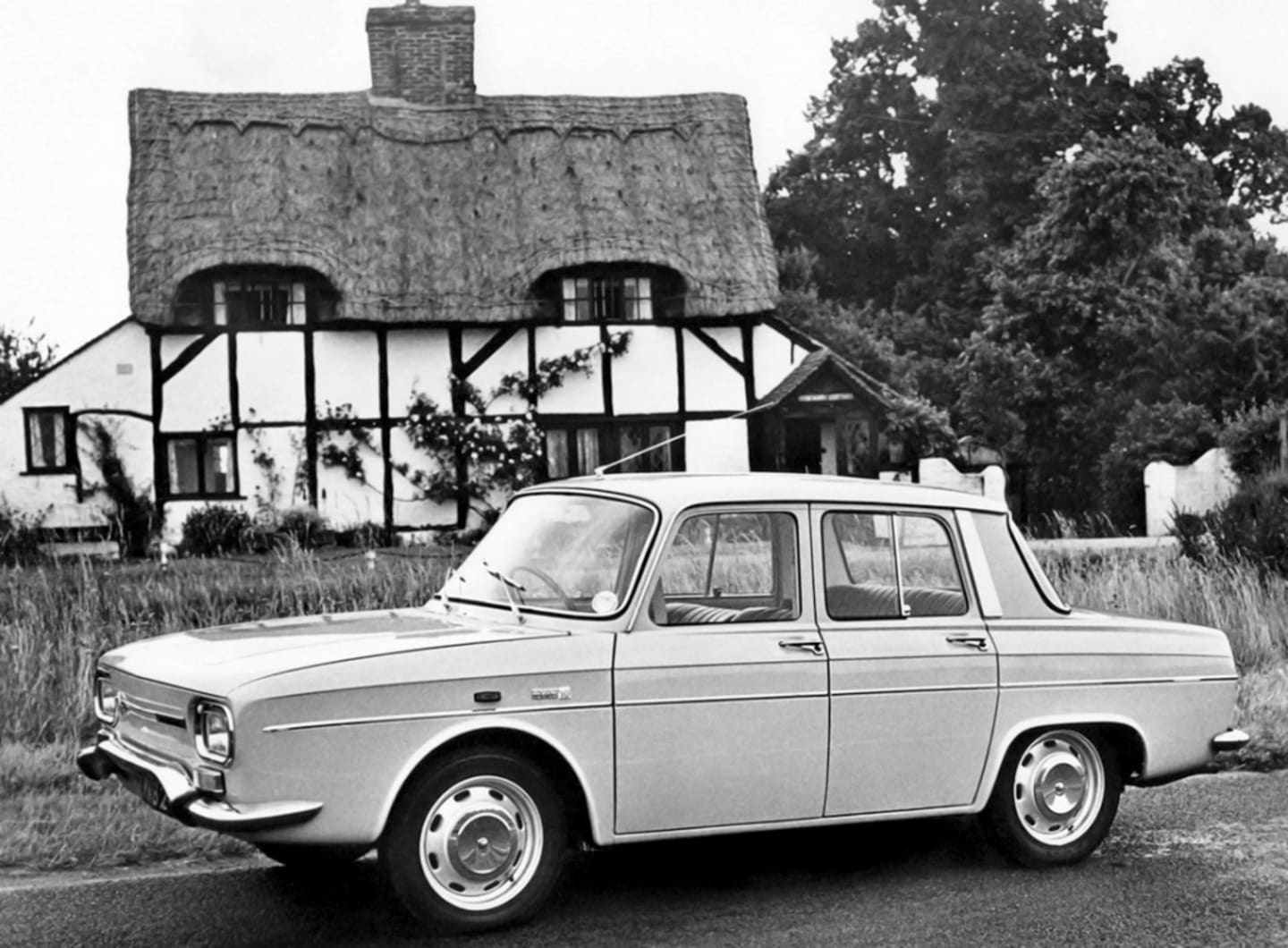 Renault 10 de profil devant une maison de campagne
