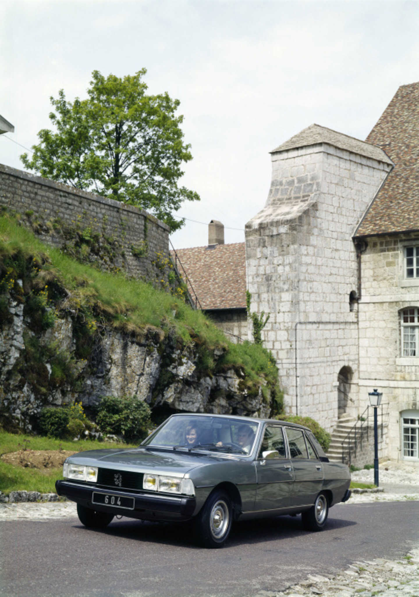 Peugeot 604 roulant dans une ville médiévale