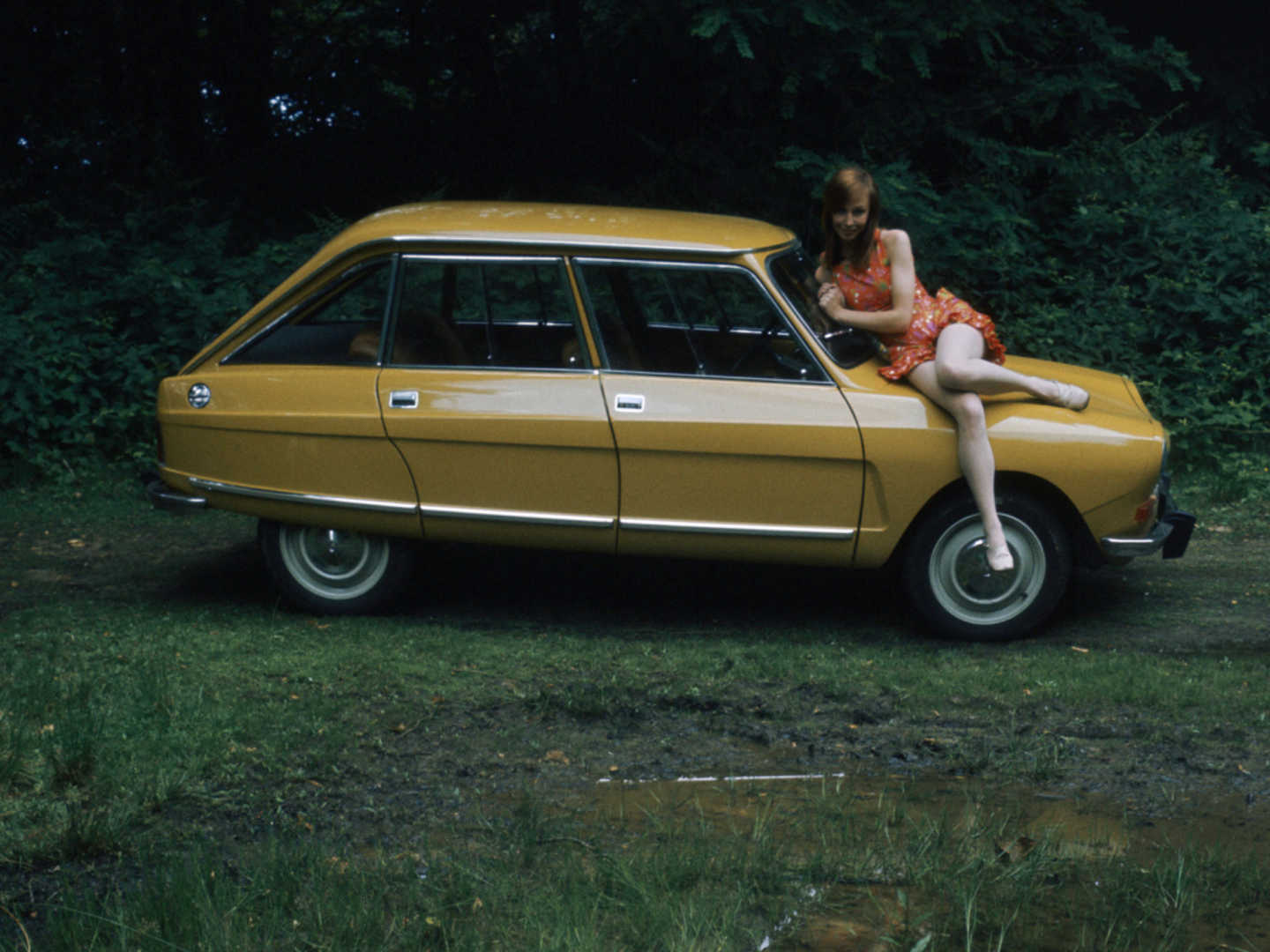 Citroën Ami8 jaune de profil avec une femme sur le capot