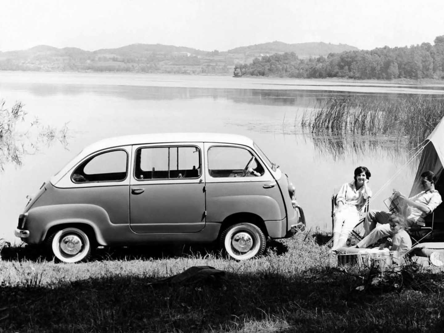Fiat 600 Multipla au bord d'un étang avec une famille faisant du camping