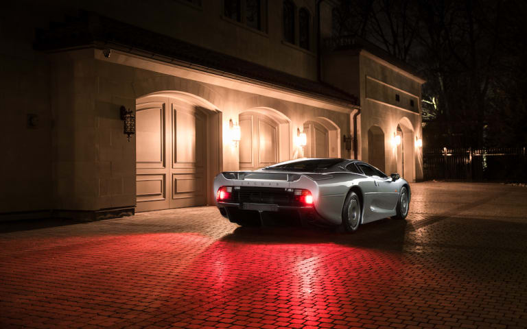 Jaguar XJ220 devant une villa de nuit
