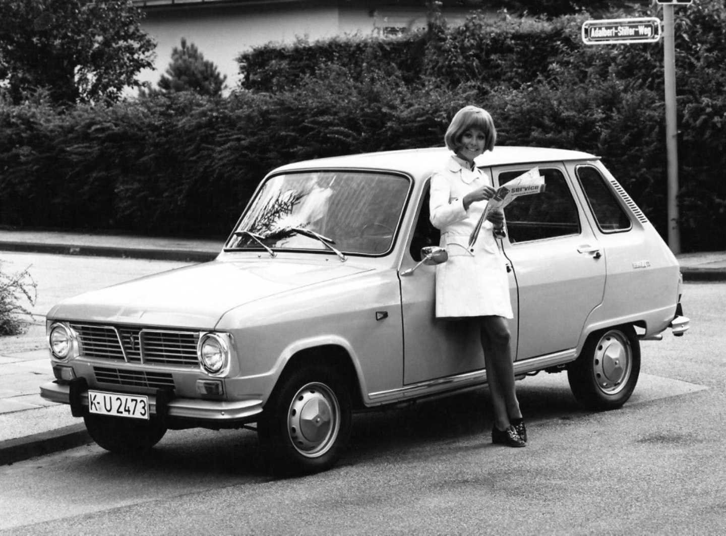 Renault 6 dans la rue avec une femme adossée à la porte conducteur