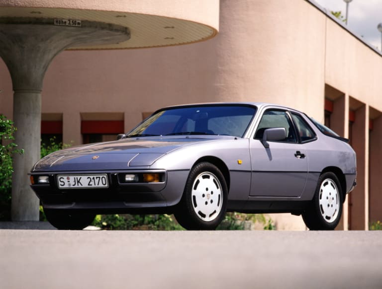 Porsche 924 S grise devant un bâtiment