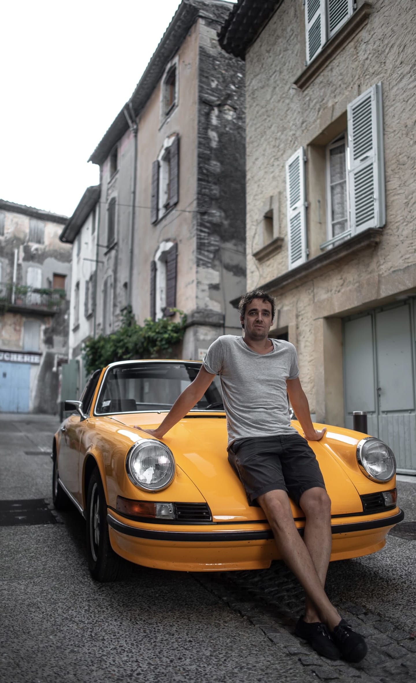 Vincent sur le capot de sa Porsche orange