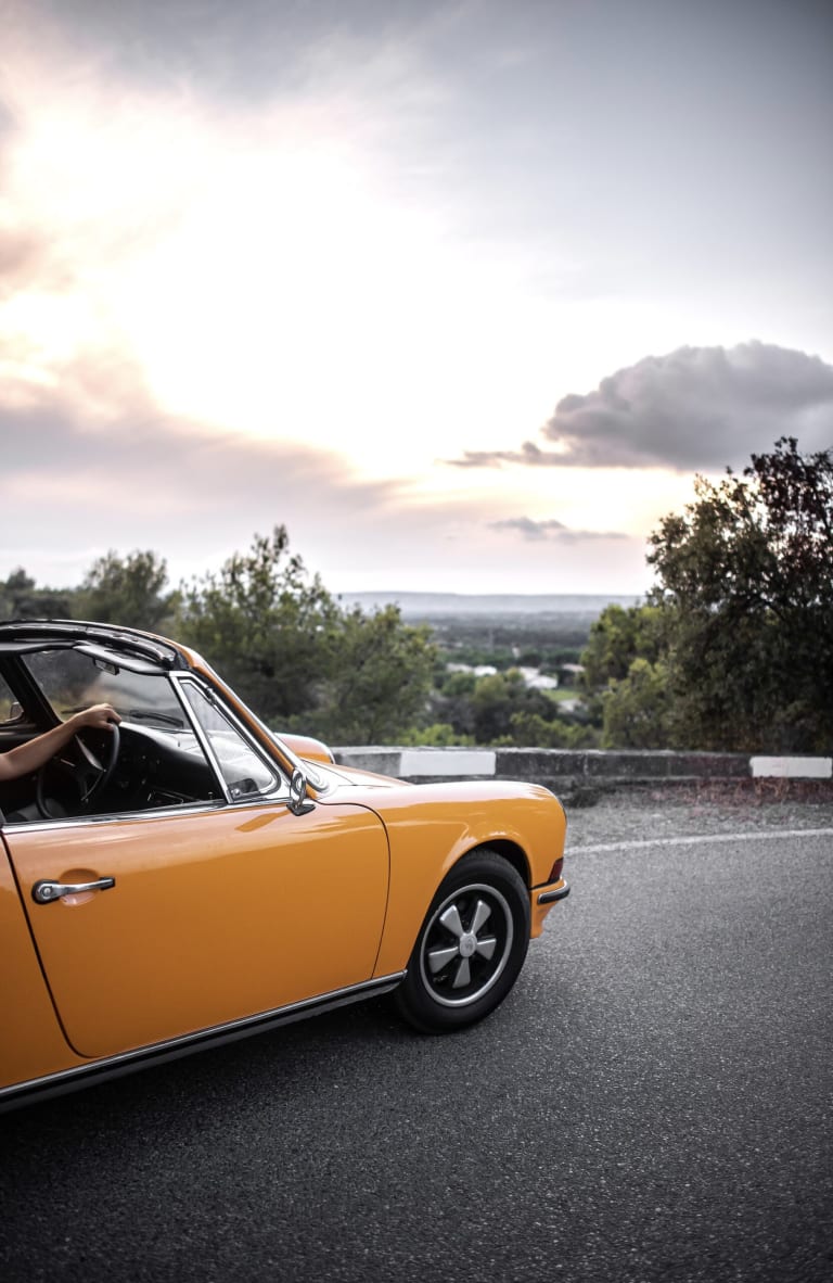 Avant de la Porsche 911 avec un coucher de soleil en fond