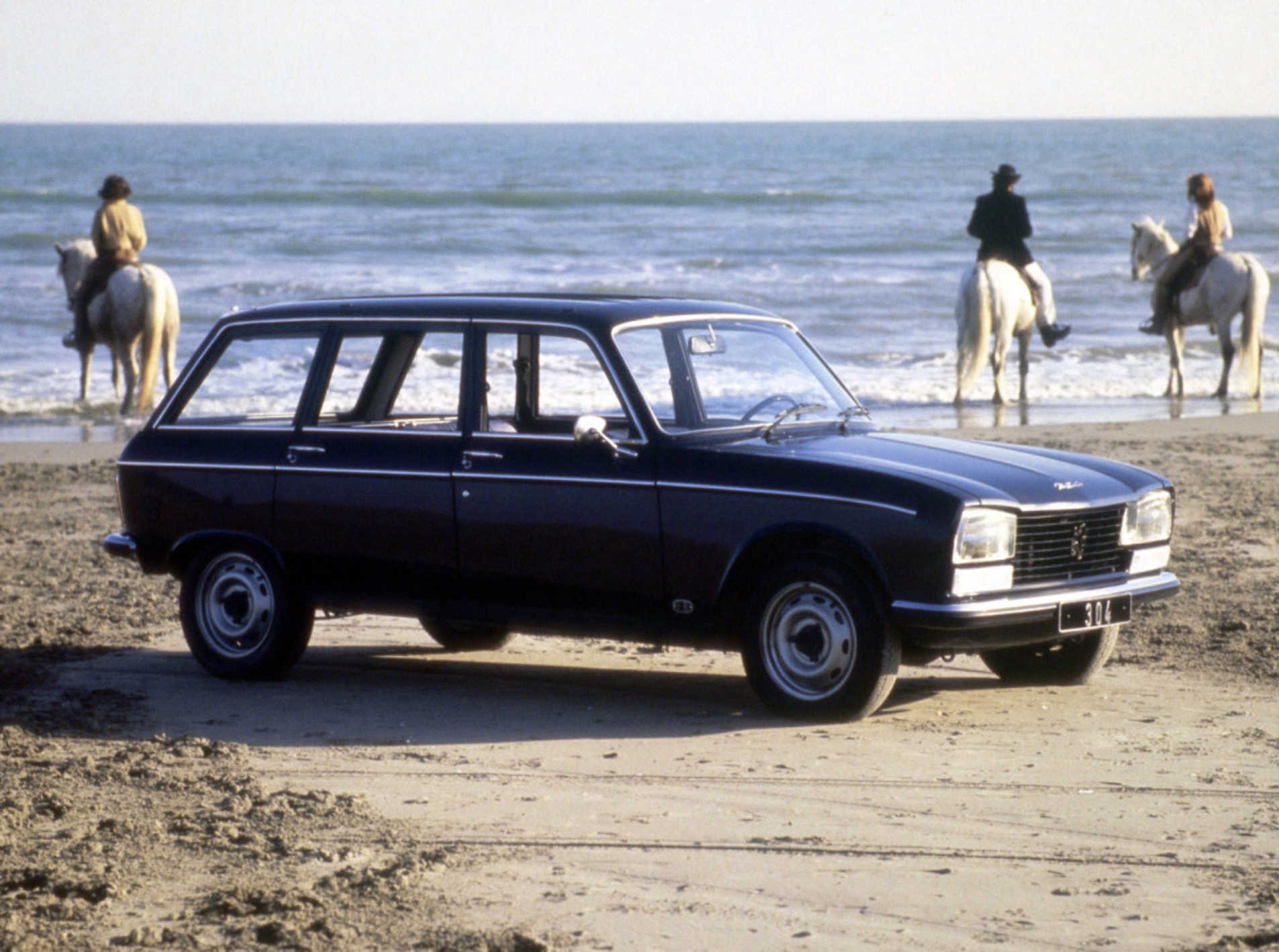 Peugeot 304 stationné sur une plage avec une vue d'ensemble de l'auto