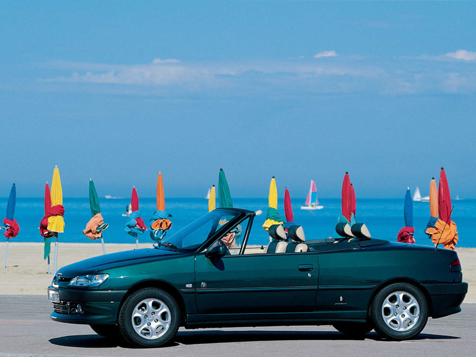 Peugeot 306 Cabriolet garé au bord de la plage avec une vue sur le côté