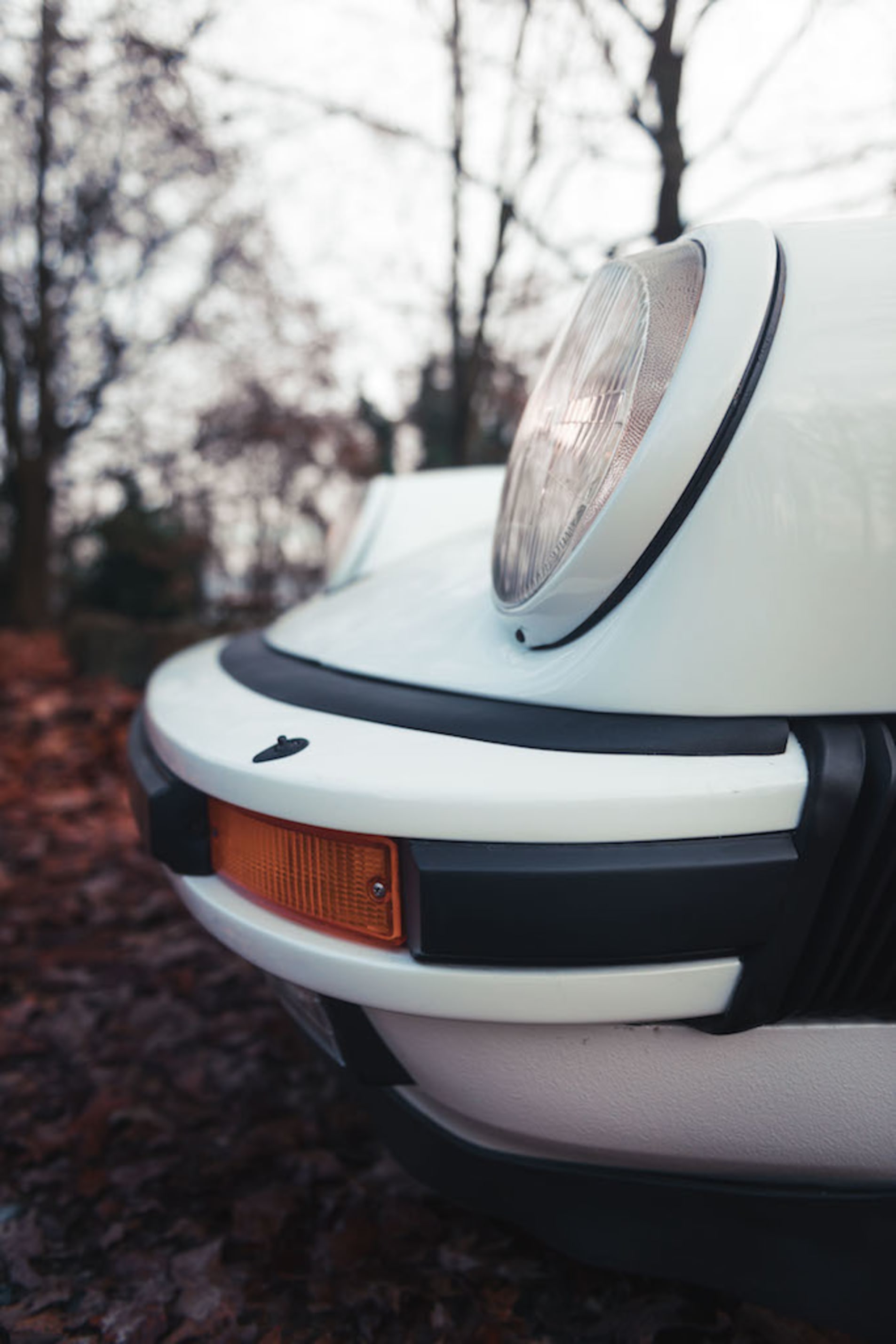 Porsche 911 Carrera blanche zoom sur le phare avant